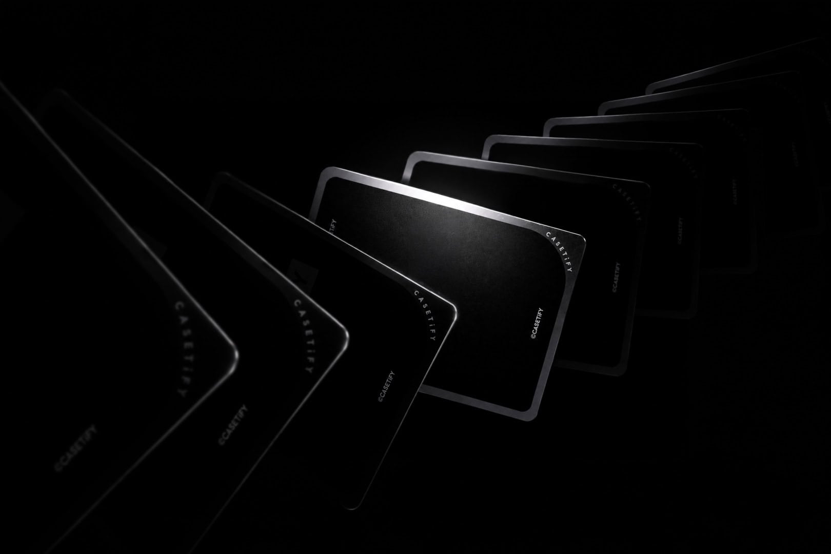 Casetify Cards 3 | The Outerhaven Black playing cards fanned in an arc against a dark background, silver-edged.
