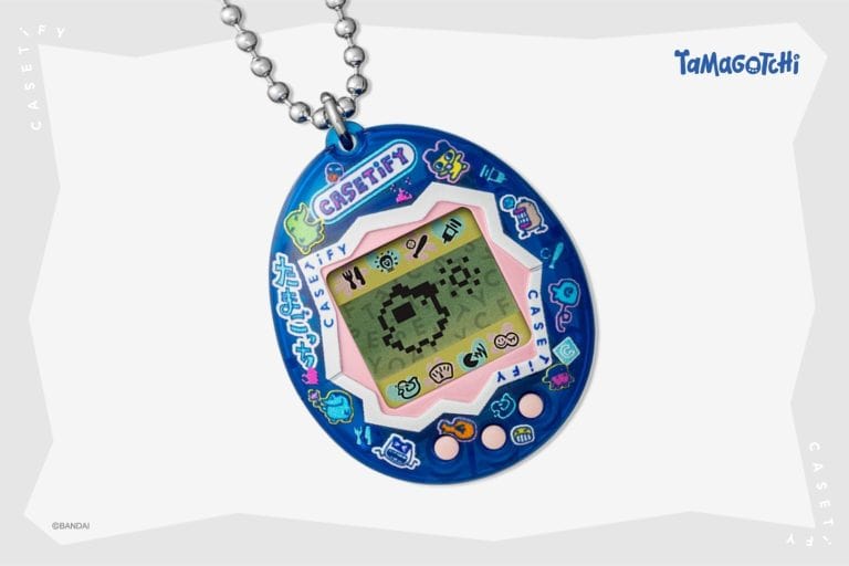 Tamagotchi | The Outerhaven Blue Tamagotchi pendant with pink inner frame and a pixel art LCD display on top of a metal ball chain