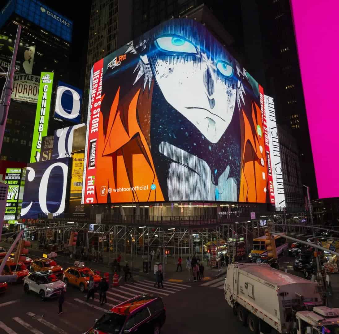 FOG LAND Times Square_3 | The Outerhaven Nighttime Times Square with a giant animated billboard showing a stylized blue-eyed character, bright colors and surrounding signage.