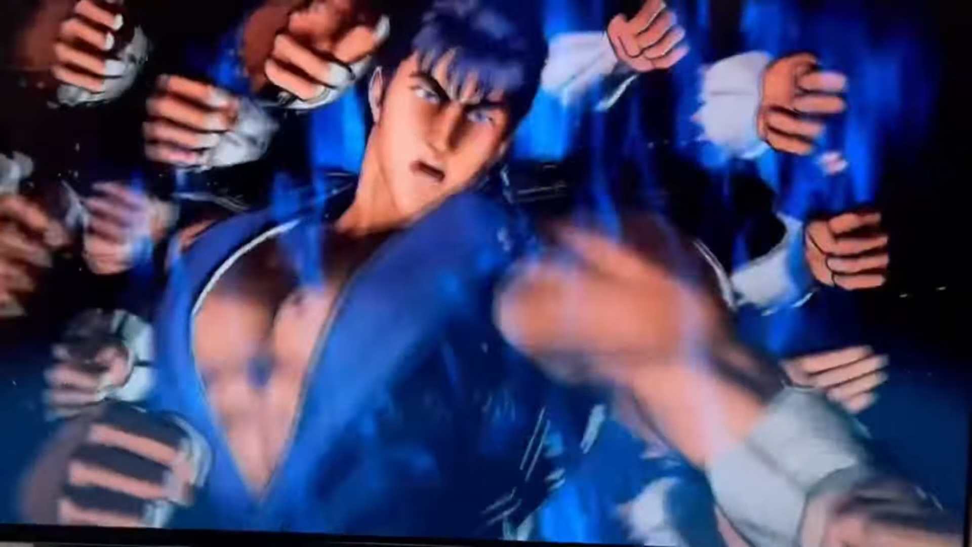 Fatal Fury COTW _ new gameplay footage of Kenshiro 0-8 screenshot | The Outerhaven A crowd of fans in blue clothing raising their arms and fists around a central person at what appears to be a sports or concert crowd scene.