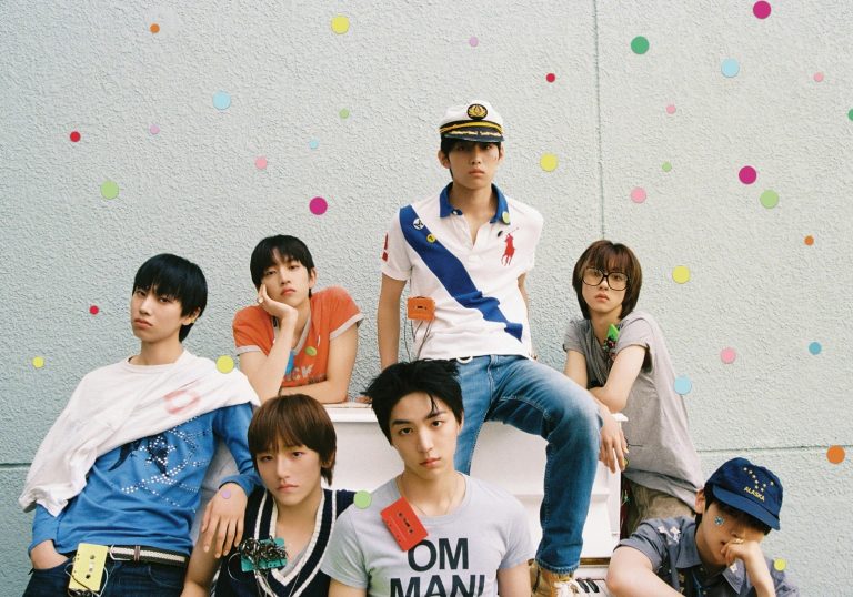 IDID_FLY_1 | The Outerhaven Seven young men pose together against a light-textured wall with colorful circular confetti scattered around. The central figure wears a captain's hat and white polo with a blue sash.