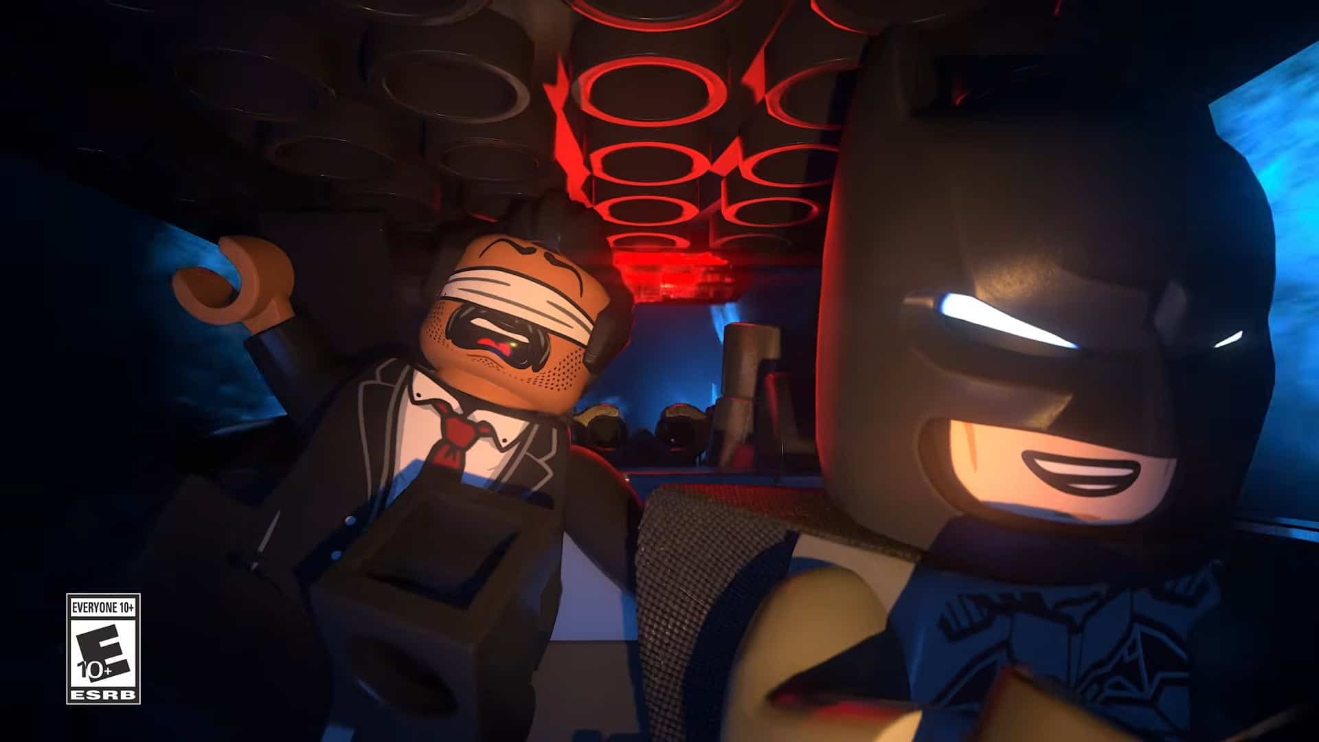 LEGO® Batman™_ Legacy of the Dark Knight Official Launch Trailer 0-3 screenshot 1 | The Outerhaven Two LEGO characters—Batman on the right and a bruised-in-the-face thug on the left—in a dark, neon-lit scene with red circular lights overhead, suggesting a tense showdown in a LEGO setting. ESRB rating 10+ label visible in the corner.