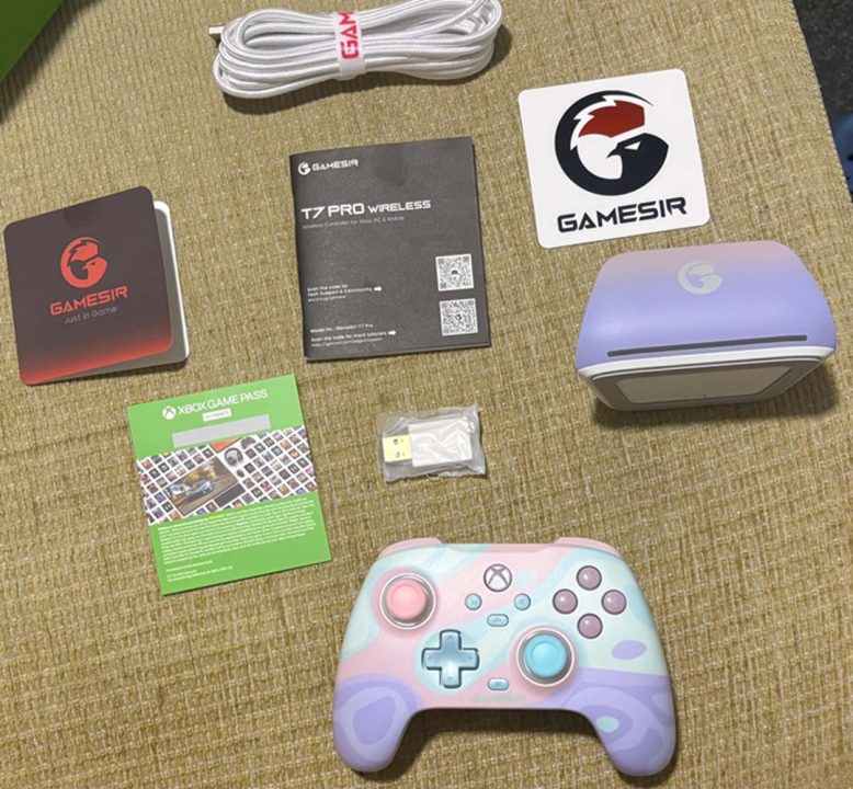 Gamesir Box Contents | The Outerhaven Pastel-colored Xbox-style controller on a beige carpet with Gamesir gear (T7 Pro Wireless, stickers, and cables) around it, plus an Xbox Game Pass card.