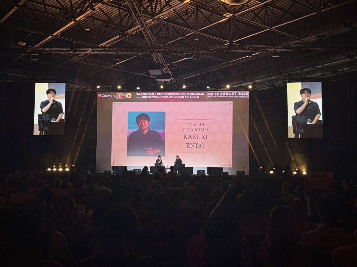 Japan Expo | The Outerhaven Stage event with a large pink screen showing a portrait and the name Kazuki Endo; two people seated on stage, audience in front.