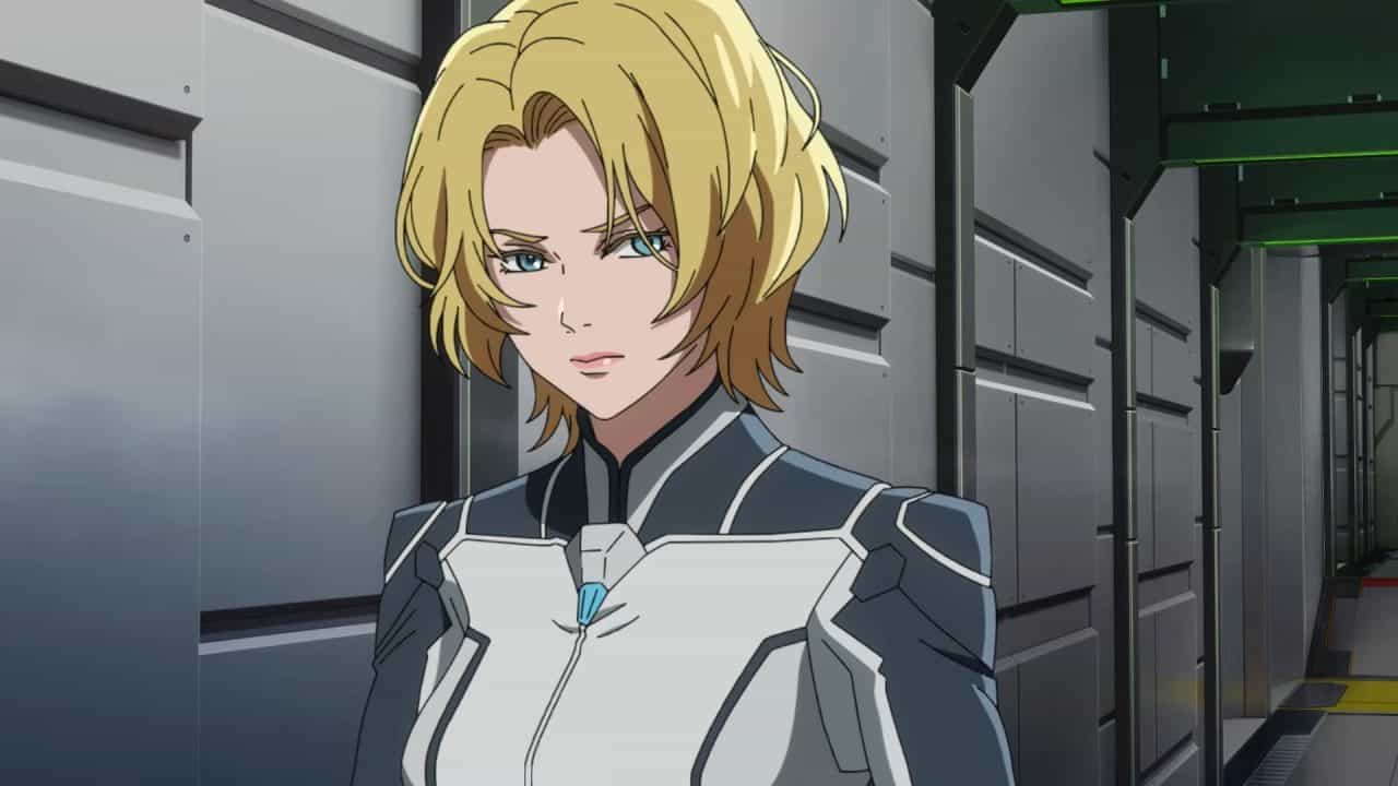 _Mobile Suit Gundam RG XARX-ZERO_ Teaser 0-48 screenshot | The Outerhaven Anime-style woman with short blonde hair in white-gray armor leaning against a metal wall in a high-tech corridor.