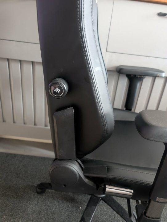 BAP Side | The Outerhaven Ergonomic office chair side view showing a lever and adjustment knob for height/tilt, with black leather upholstery and a chrome gas lift.