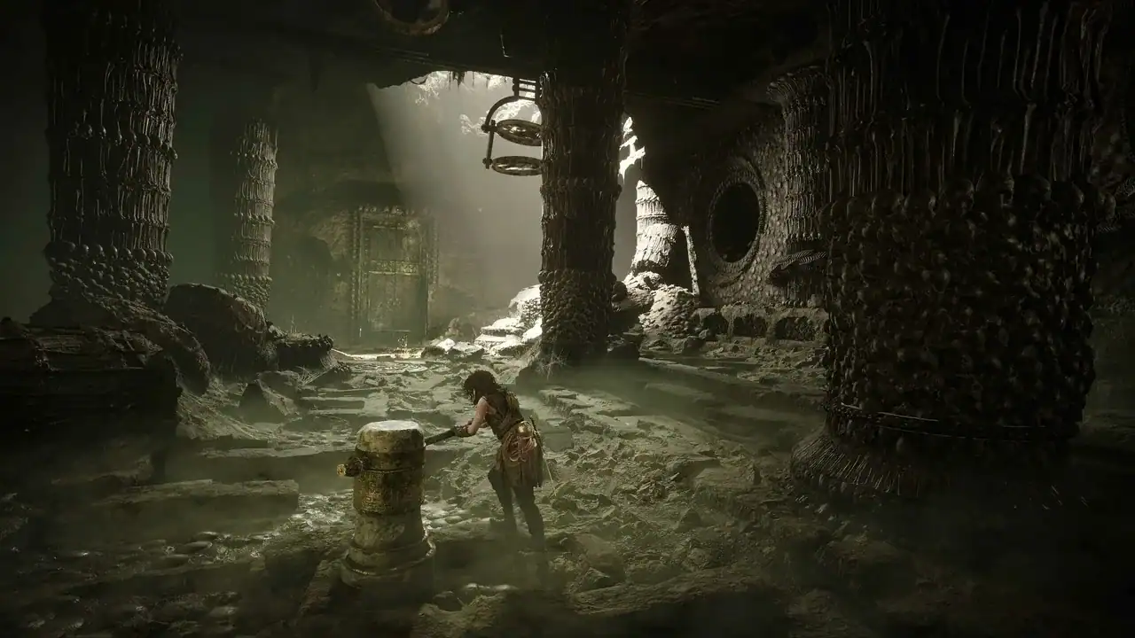 Resonance-A-Plague-Tale-Legacy-screenshot04 | The Outerhaven Adventurer crouching by a weathered pedestal in a dark subterranean temple with carved stone columns.