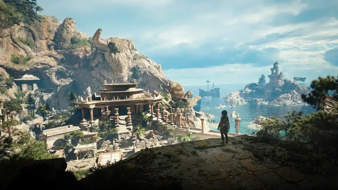 Resonance-A-Plague-Tale-Legacy-screenshot06 | The Outerhaven A lone explorer stands on a rocky ledge overlooking ancient ruins by the sea, with a distant ship and rocky island in the background.