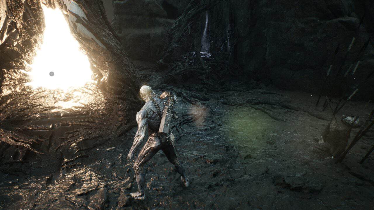 Armored, muscular character in a dark cavern with a glowing lava-like pool on the left and weapons on his back.
